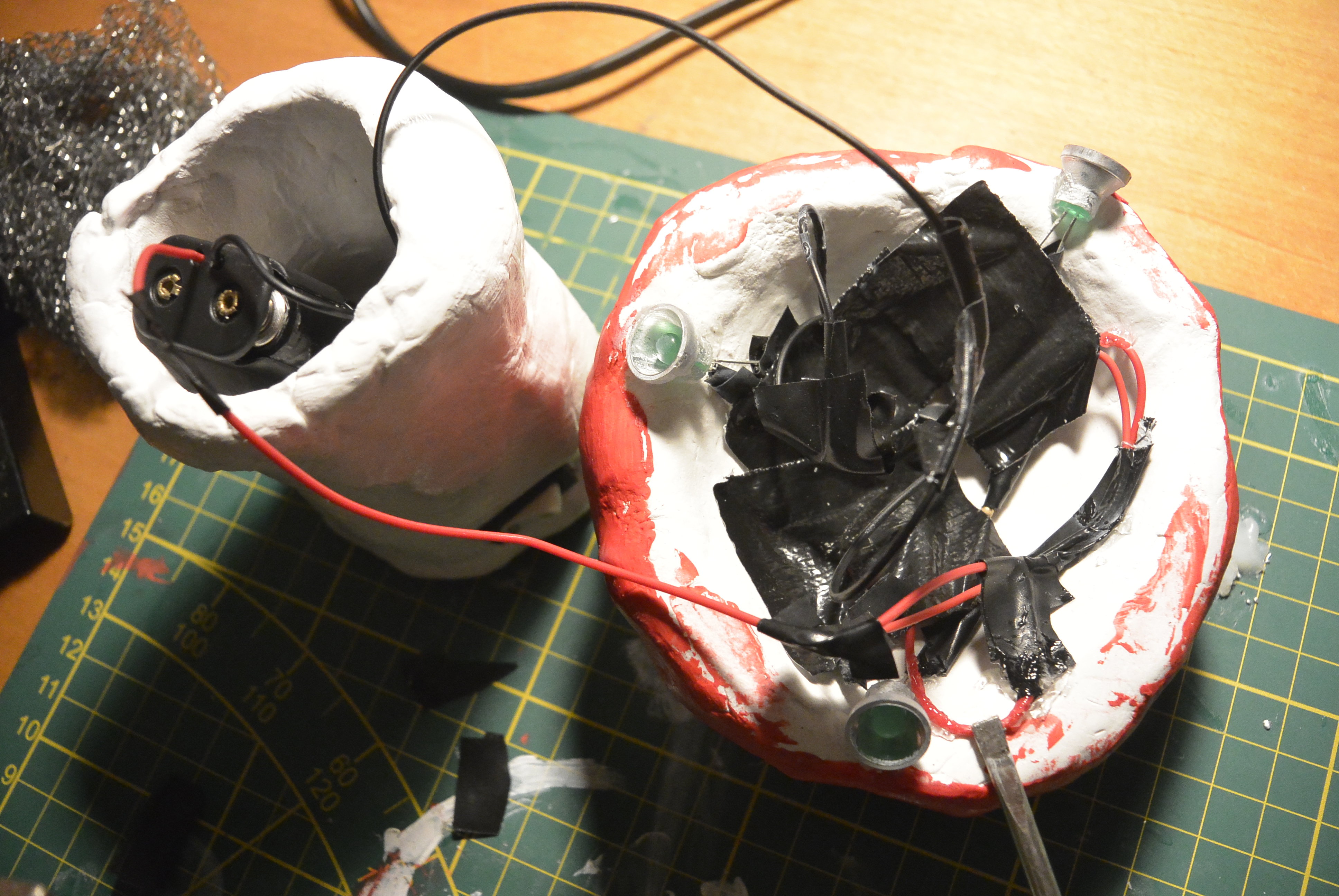 A picture of messy wires and leds glued onto dry clay